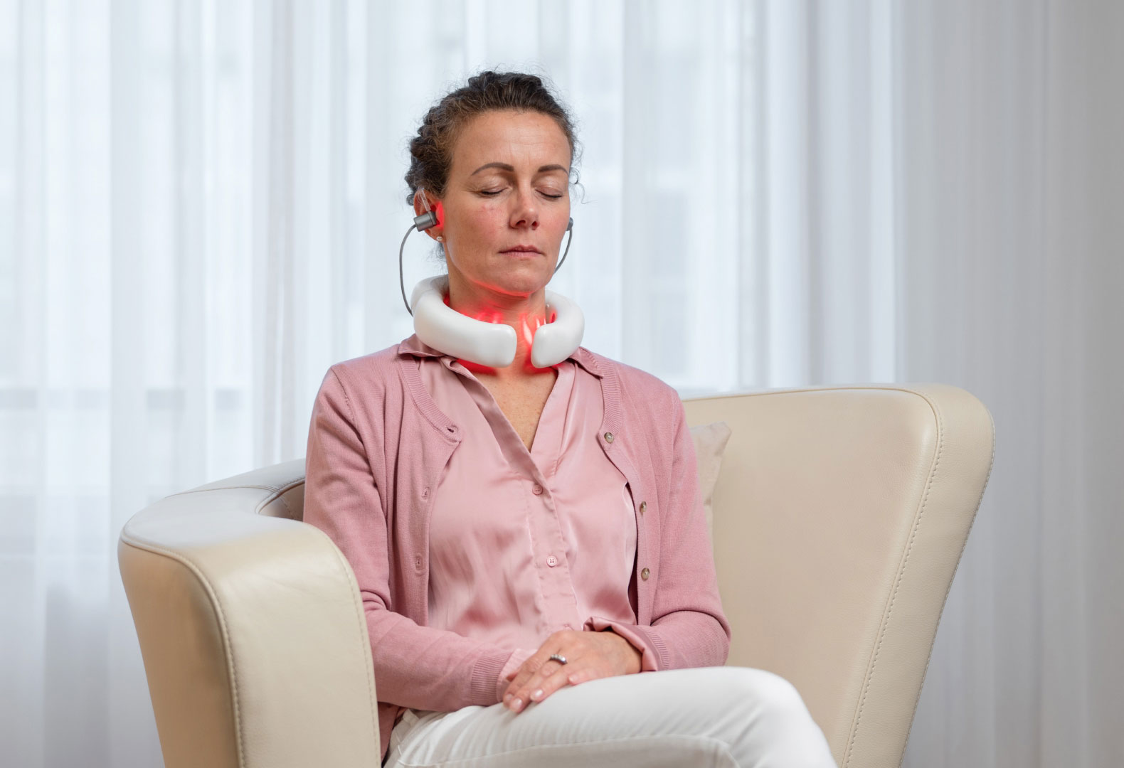 Frau nutzt das LumoHome Lasertherapiegerät entspannt im Sitzen