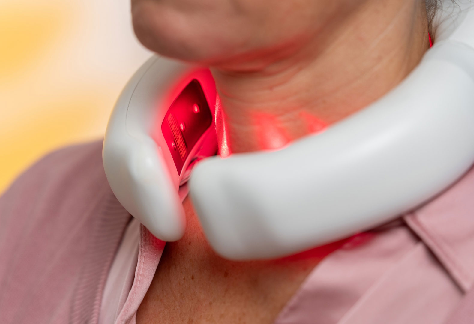 Nahaufnahme der LumoHome Lasertherapie am Nacken während der Anwendung